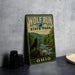 A vintage-style metal sign for Wolf Run State Park in Ohio, featuring a wolf standing on a rock overlooking a river surrounded by trees.