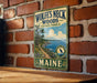 A vintage-style metal sign for Wolf's Neck Woods State Park in Maine, featuring a scenic landscape with a path leading to a body of water and a bird.
