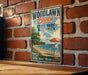 A vintage-style metal sign for Woodlawn Beach State Park in New York, featuring a beach scene with a lifeguard chair and an umbrella.