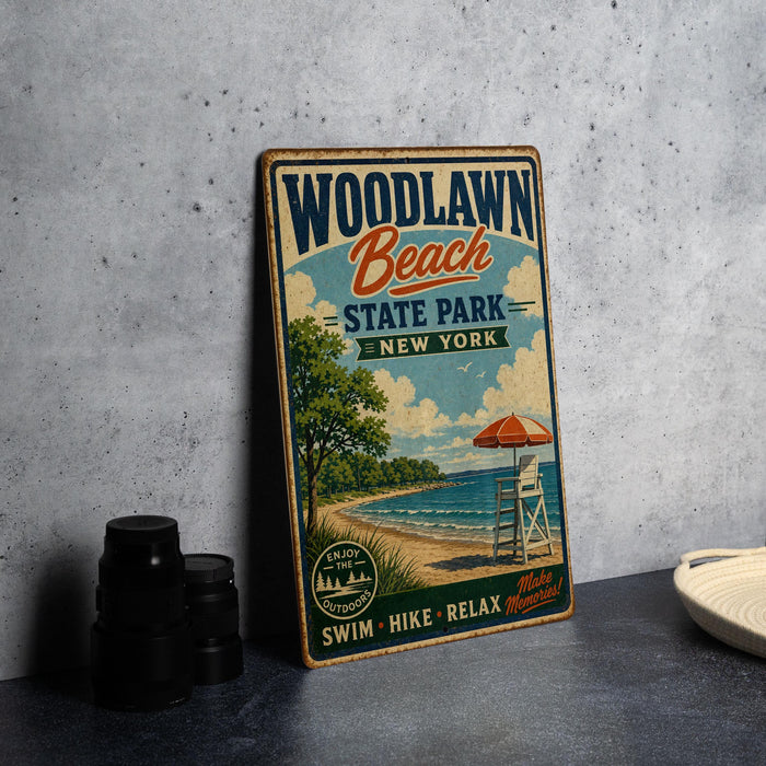 A vintage-style sign for Woodlawn Beach State Park in New York, featuring a beach scene with an umbrella, lifeguard chair, and a scenic view of the ocean.