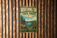 A vintage metal sign for WorthINGTON STATE FOREST NEW JERSEY, featuring a scenic landscape with pine trees, a lake, and mountains.