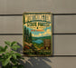 A vintage metal sign for Worthington State Forest in New Jersey, featuring a scenic landscape with pine trees, a lake, and mountains.