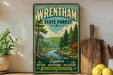 A vintage-style sign for Wrentham State Forest, featuring a scenic illustration of a forest landscape with a river and mountains in the background.