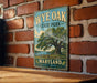 A vintage-style metal sign for Wye Oak State Park in Maryland, featuring a large tree and a serene landscape.