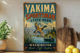 A vintage-style sign for Yakima Sportsman State Park, featuring a duck in flight over a lake, with mountains in the background.