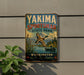 A vintage-style metal sign for Yakima Sportsman State Park, featuring a bird in flight and a lake with a boat, mounted on a wall.