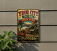 A vintage-style metal sign for Ybor City Museum, featuring a trolley car and palm trees, is displayed on a wall.