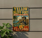 A vintage-style metal sign for Yellow Bluff Fort Historic State Park, featuring a palm tree, a fort, and the text "Yellow Bluff Fort" and "FLORIDA".