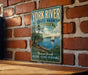 A vintage-style metal sign for York River State Park, Virginia, featuring a scenic illustration of a sailboat on a river surrounded by lush greenery.