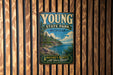 A vintage metal sign for Young State Park in Michigan, featuring a scenic landscape with a lake and mountains.