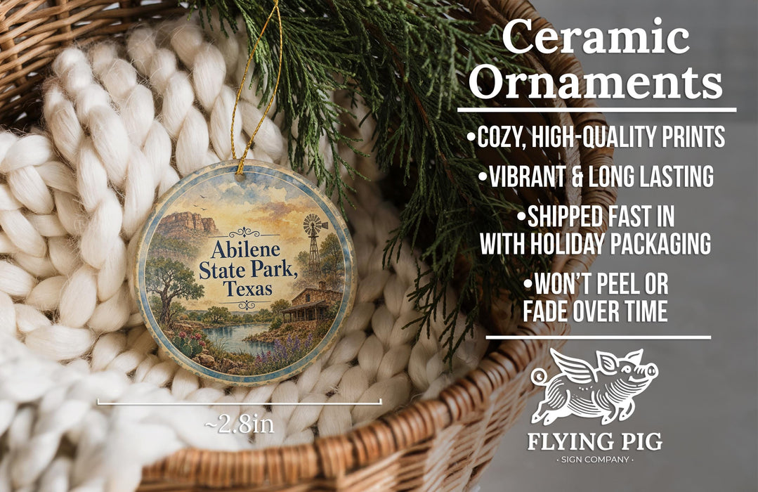 Ceramic ornaments, featuring a Texas landscape, are displayed in a basket with greenery.