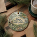 A decorative ornament with a scenic image of Aiken State Park, South Carolina, hanging on a wooden surface.