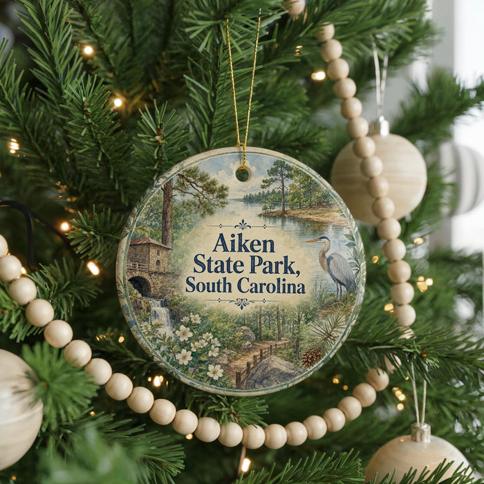 A Christmas tree decorated with ornaments, including a circular ornament with a scenic image of Aiken State Park, South Carolina.