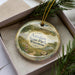 A decorative ornament in a box, featuring a scenic landscape of Aztec State Park, Wisconsin.