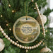 A round ornament hanging on a Christmas tree, featuring a scenic landscape with a path and a sign that reads "Aztalan State Park, Wisconsin".