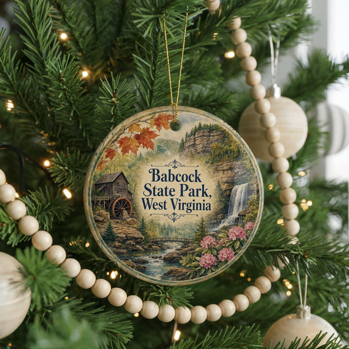 A round ornament on a Christmas tree, featuring a scenic image of Babcock State Park in West Virginia.