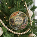 A round ornament on a Christmas tree, featuring a scenic image of Babcock State Park in West Virginia.