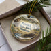 A decorative ornament in a box, featuring a scenic image of Banack State Park, Montana.