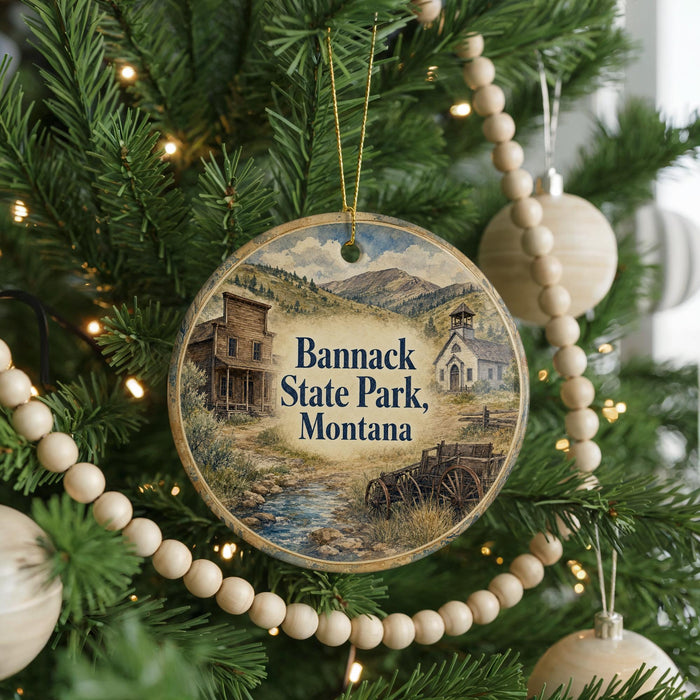 A round ornament hanging on a Christmas tree, featuring a scenic image of Banack State Park, Montana.