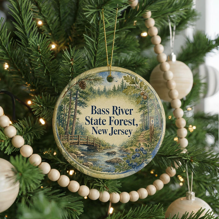 A round ornament hanging on a Christmas tree, featuring a scenic image of the Bass River State Forest in New Jersey.