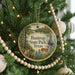 A round ornament hanging on a Christmas tree, featuring a scenic image of Bastrop State Park, Texas.