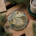 A decorative ornament featuring a scene from the Battle of Athens, Missouri, with a wagon and a cabin in the background.