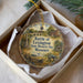 A decorative ornament in a box, featuring an illustration of a historical battle scene with a monument and buildings in the background.