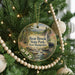 A circular ornament hanging on a Christmas tree, featuring a scenic image of Bear Brook State Park in New Hampshire.