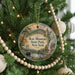 A round ornament hanging on a Christmas tree, featuring a scenic image of Bear Mountain State Park, New York.