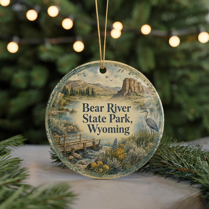 A round ornament with a scenic landscape of Bear River State Park, Wyoming, featuring a bird, a bridge, and mountains in the background.