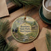 A circular ornament featuring a scenic image of Beartown State Park in West Virginia, with a bear and a cabin in the background.