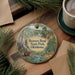 A circular ornament featuring a scenic image of Beaver Bend State Park in Oklahoma, with a bear and deer in the foreground and a waterfall in the background.