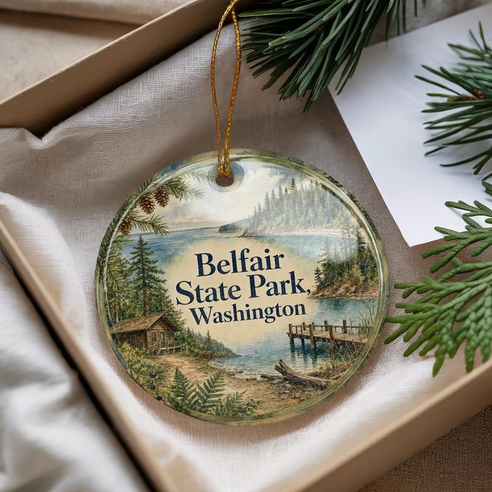 A round ornament with a scenic image of Belfair State Park in Washington, featuring a cabin, pine trees, and a body of water.