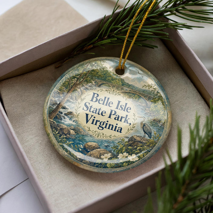 A decorative ornament in a box, featuring a scenic landscape with a bird and water, along with the text "Belle Isle State Park, Virginia".