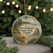A round ornament with a scenic beach landscape and text that reads "Beverly Beach State Park, Oregon" is displayed on a table with pine branches in the background.