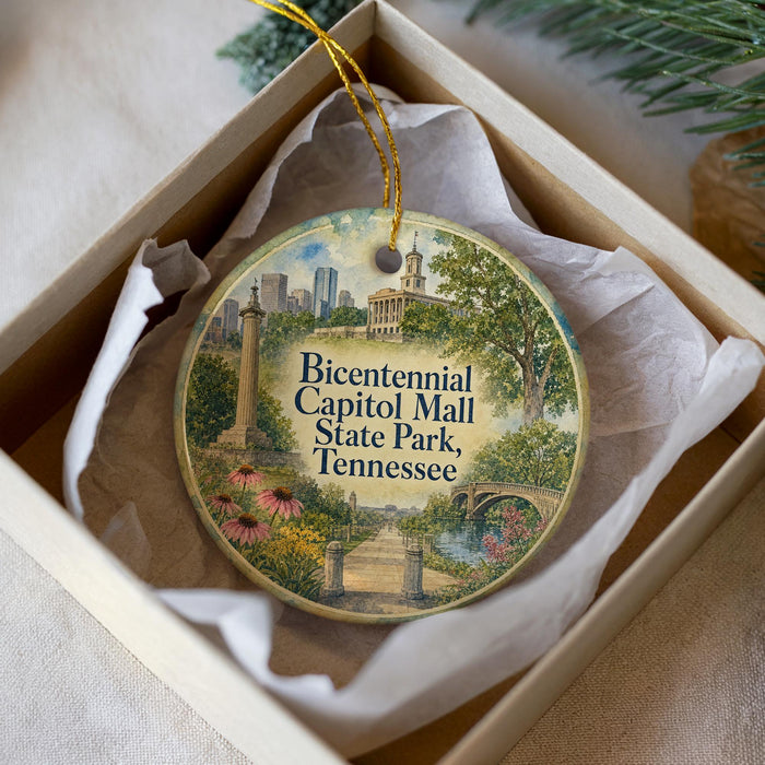 A decorative ornament in a box, featuring a painting of the Capitol Mall in Tennessee.