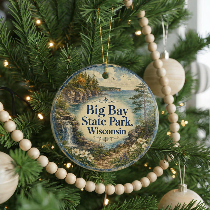 A circular ornament hanging on a Christmas tree, featuring a scenic landscape of Big Bay State Park in Wisconsin.