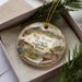 A decorative ornament in a box, featuring a scenic image of Big Bend Ranch State Park in Texas.
