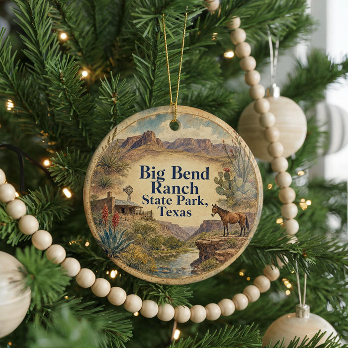 A round ornament hanging on a Christmas tree, featuring a desert landscape with mountains, a horse, and a windmill.