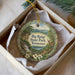 A decorative ornament in a box, featuring a scenic landscape with a waterfall and pine trees, with the text "Big Ridge State Park, Tennessee" printed on it.