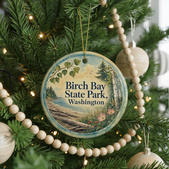 A round ornament hanging on a Christmas tree, featuring a scenic image of Birch Bay State Park in Washington.