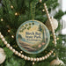 A round ornament hanging on a Christmas tree, featuring a scenic image of Birch Bay State Park in Washington.