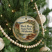 A Christmas tree decorated with ornaments, including a circular ornament with a scenic image of Black Mesa State Park, Oklahoma.