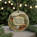A decorative ornament featuring a scenic landscape with mountains, trees, and a body of water, hanging from a string.