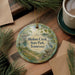 A round ornament with a scenic illustration of Bledsoe Creek State Park, Tennessee, hangs on a wooden surface.