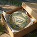 A decorative ornament in a wooden box, featuring a scenic landscape with a house and flowers, with the text "Blue Mound State Park, Wisconsin" prominently displayed.
