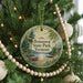 A round ornament hanging on a Christmas tree, featuring a scenic image of a lake and a boat, with the text "Bomoseen State Park, Vermont" displayed prominently.