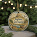 A round ornament with a scenic illustration of a mountain, windmill, and deer, hanging from a string.