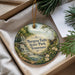 A decorative ornament with a scenic image of a waterfall and greenery, hanging from a string.