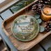 A decorative ornament featuring Burnham Point State Park, New York, with a scenic landscape of a lake, mountains, and pine trees.